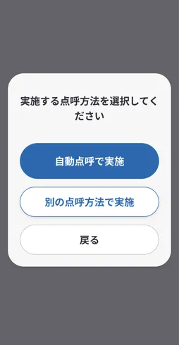 アプリ画面で、点呼方法を選択するダイアログが表示されている。「自動点呼で実施」と「別の点呼方法で実施」の2つの青いボタンと「戻る」ボタンがある。